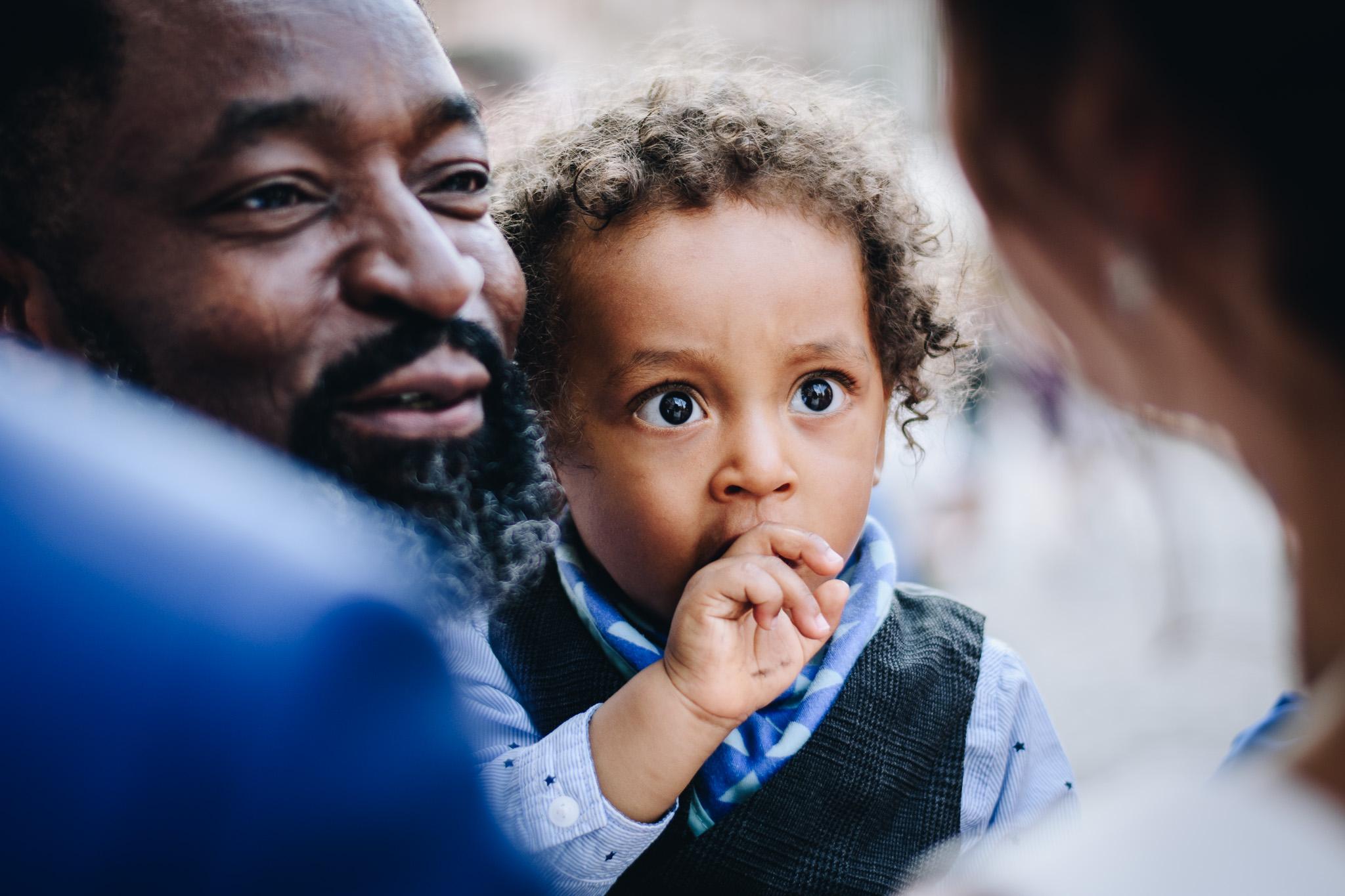 Czarnoskóre małe dziecko patrzy wielkimi oczami na pannę młodą