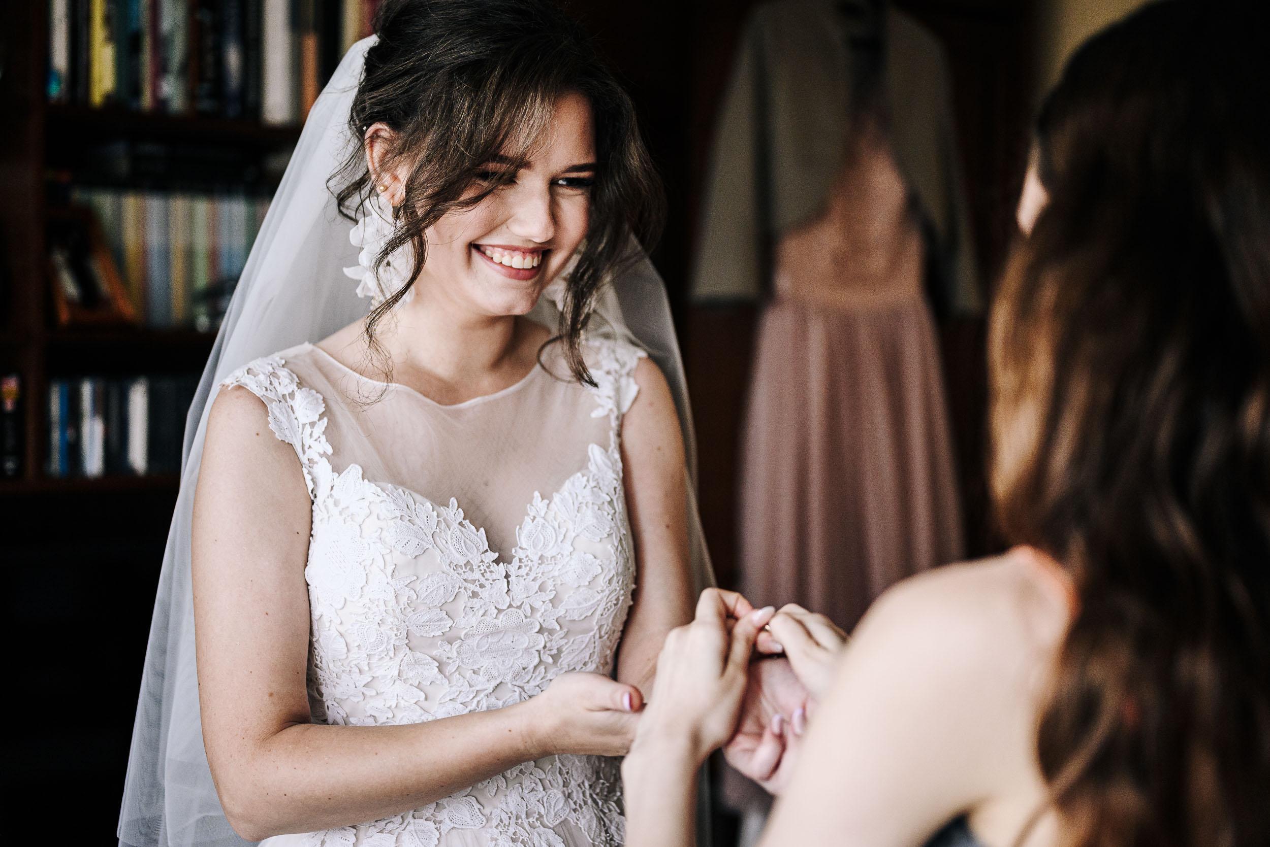 Panna młoda uśmiecha się podczas przygotowań do swojej świadkowej