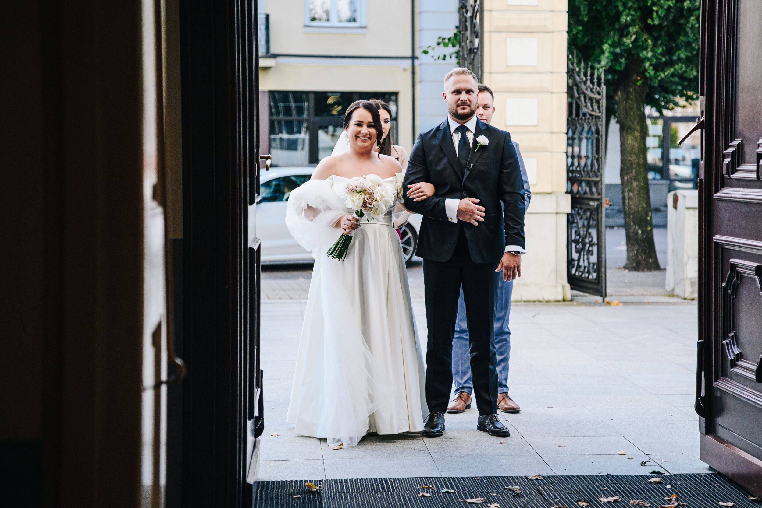 Młoda para czeka w drzwiach kościoła na wejście.